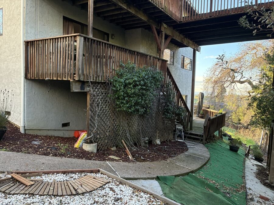 Multi-level wooden deck on a hillside home in the San Jose foothills, with the Santa Clara Valley in the distance